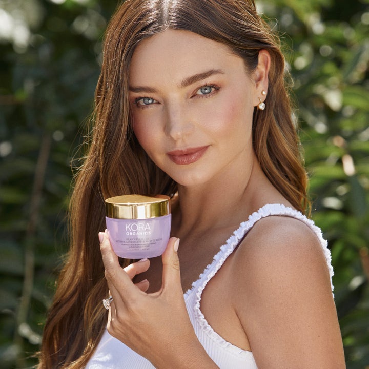 KORA Organics Plant Stem Cell Retinol Alternative Moisturizer 50 ml ansiktskrem i lilla krukke holdt av kvinne.