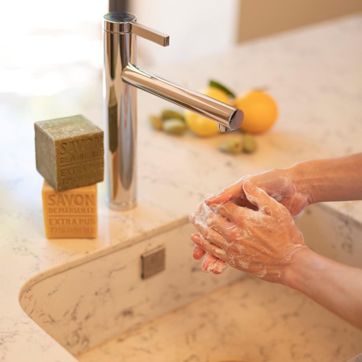 Compagnie de Provence Cube Of Marseille Soap Olive 400 g rensende håndsåpe som skummer mellom hender ved en vask
