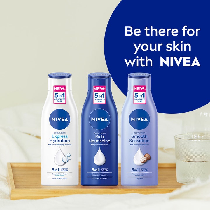 NIVEA Rich Nourishing Body Lotion 400 ml fuktighetsgivende kroppspleie i tre ulike flasker på et lyst trebrett