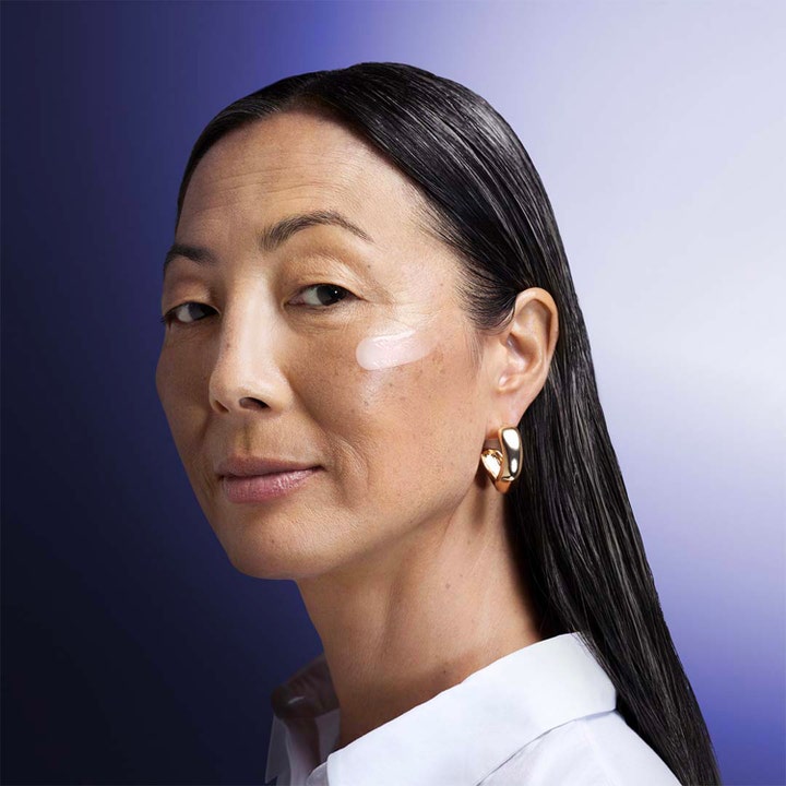 Shiseido Vital Perfection Overnight Firming Treatment 80 ml oppstrammende nattkrem påført kvinnes kinn.