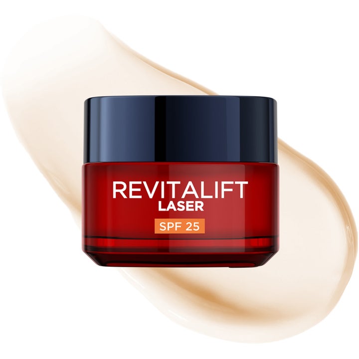 L'Oréal Paris Revitalift Laser 50 ml dagkrem med SPF 25 i rød krukke foran en lys og kremet tekstur.
