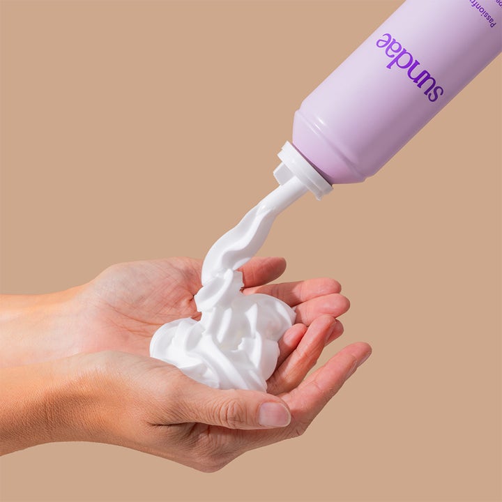Sundae Whipped Shower Foam Passionfruit Pop 265 ml dusjsåpe sprayes som fyldig hvitt skum fra en lilla boks i hendene.
