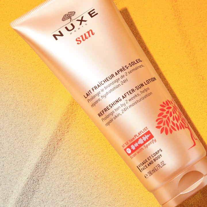 Nuxe Sun Refreshing After-Sun Lotion 200 ml fuktighetsgivende aftersun i bronsefarget tube på finkornet sand.