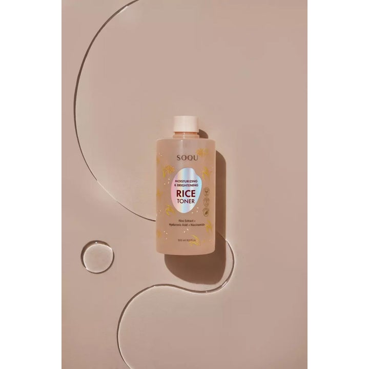 SOQU Rice Toner 500 ml fuktighetsgivende ansiktsvann i klar flaske med dråper på en beige bakgrunn