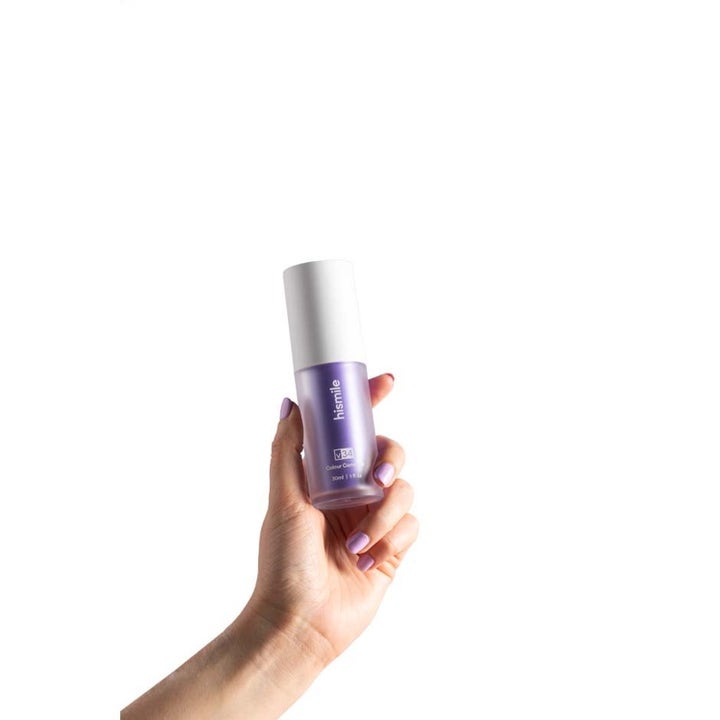Hismile Colour Corrector 30 ml lilla tannbleking i pumpeflaske som holdes av en hånd med lilla negler