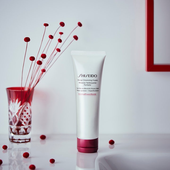 Shiseido Defend Deep Cleansing Foam 125 ml dyprensende ansiktsrens i hvit tube med rødt lokk ved siden av rød dekor.