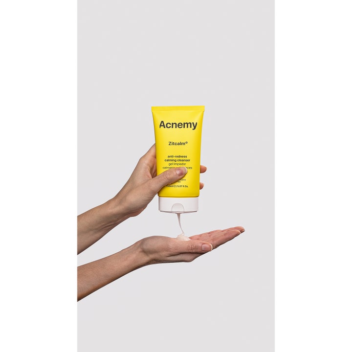 Niche Beauty Lab Acnemy Zitcalm 150 ml ansiktsrens mot rødhet klemmer ut klar gel fra en gul tube i en hånd