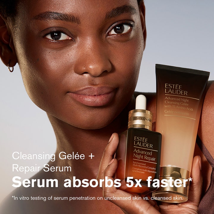Estée Lauder Advanced Night Cleansing Gelee 100 ml rengjøringsgel i tube holdt av en modell ved siden av et serum.
