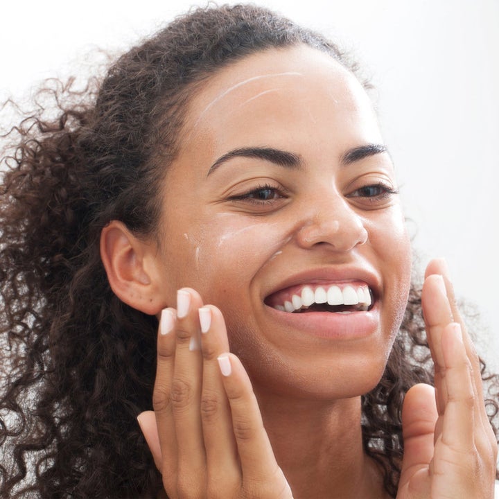 Clinique Moisture Surge & All About Clean ansiktspleie gir fukt mens en smilende kvinne påfører hvit krem