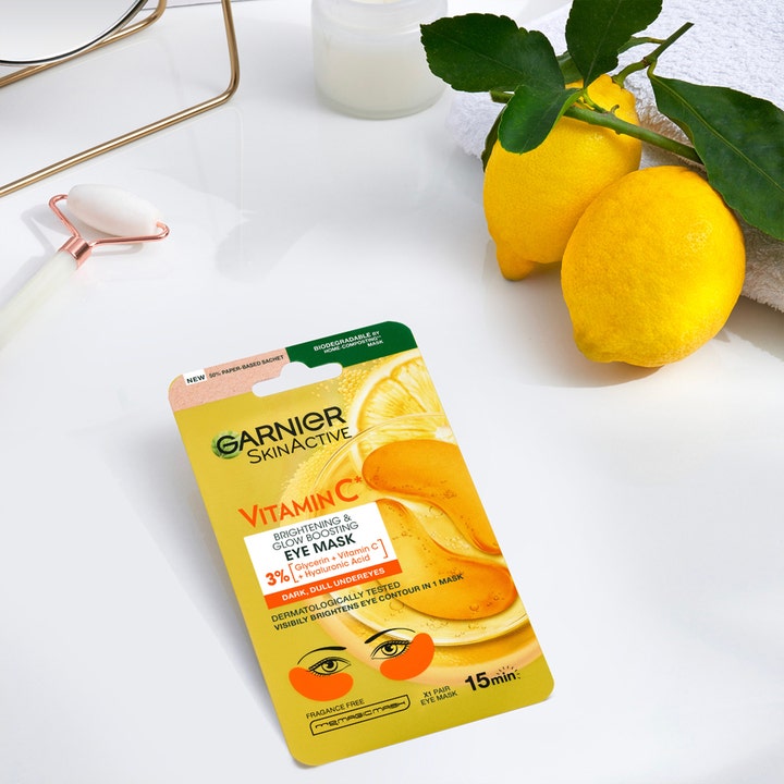 Garnier Skin Active Vitamin C 5 g øyemaske som gir glød ved siden av friske sitroner og en ansiktsrulle
