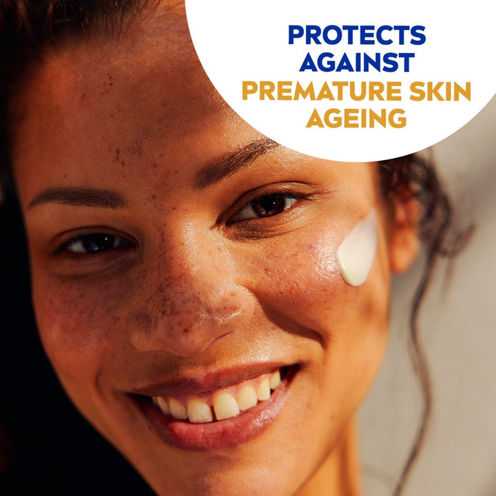 NIVEA Sun Face Shine Control Cream SPF30 50 ml solkrem ansikt mot aldring påføres kinnet til en smilende kvinne.
