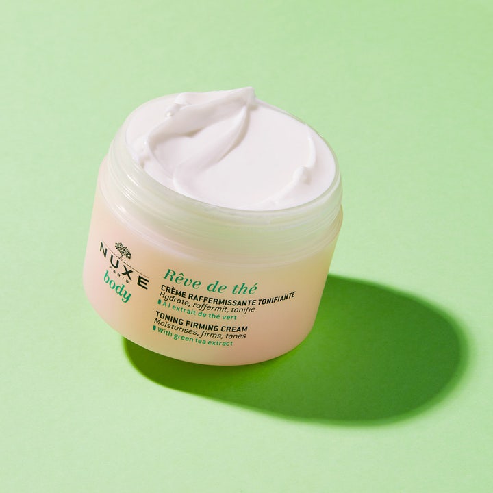 Nuxe Body Rêve De Thé Firming Cream 200 ml toner huden i en åpen krukke med hvit, fløyelsmyk tekstur.
