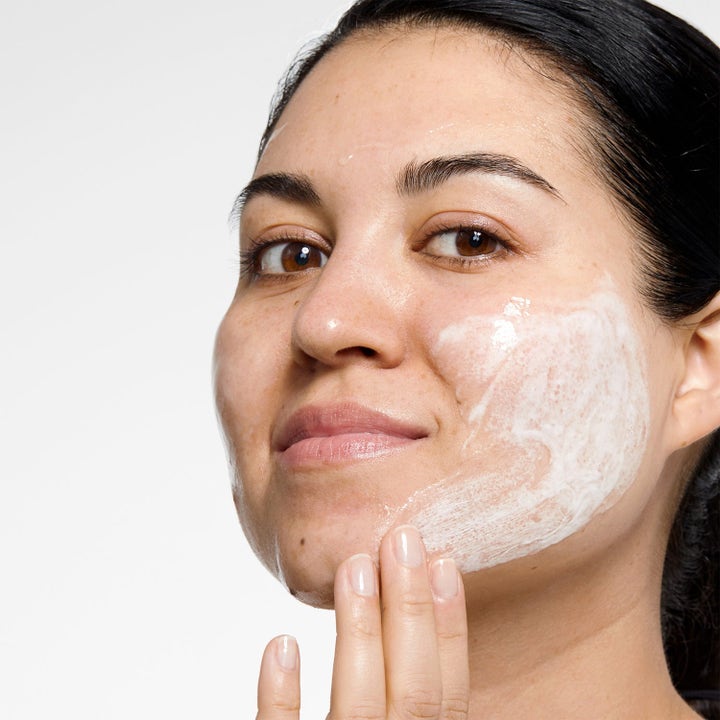 Clinique Fresh Morning 250 ml dagkrem med SPF gir fuktighet vist ved kvinne som påfører hvit krem på kinnet