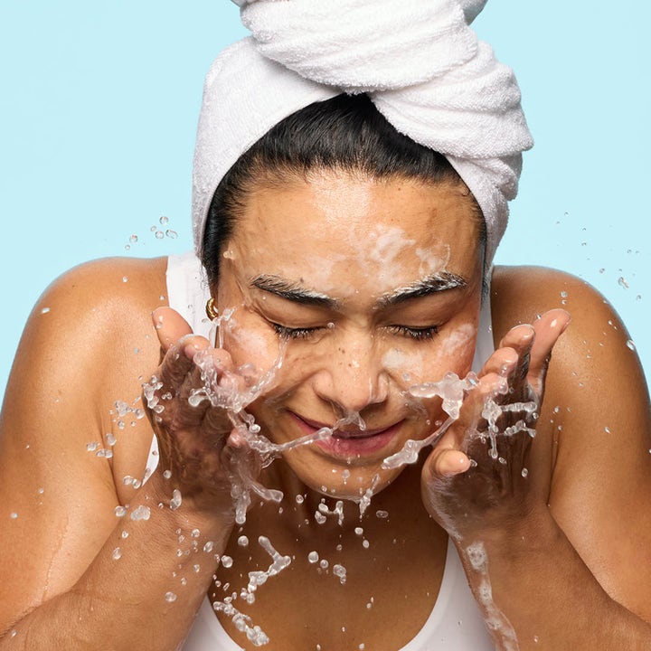 Hickap Dream Barrier Cream Cleanser 125 ml ansiktsrens som fukter mens en kvinne vasker ansiktet med vann.