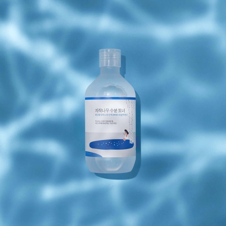 Round Lab Birch Juice Moisturizing Toner 300 ml fuktighetsgivende toner i frostet flaske mot blått vannmønster