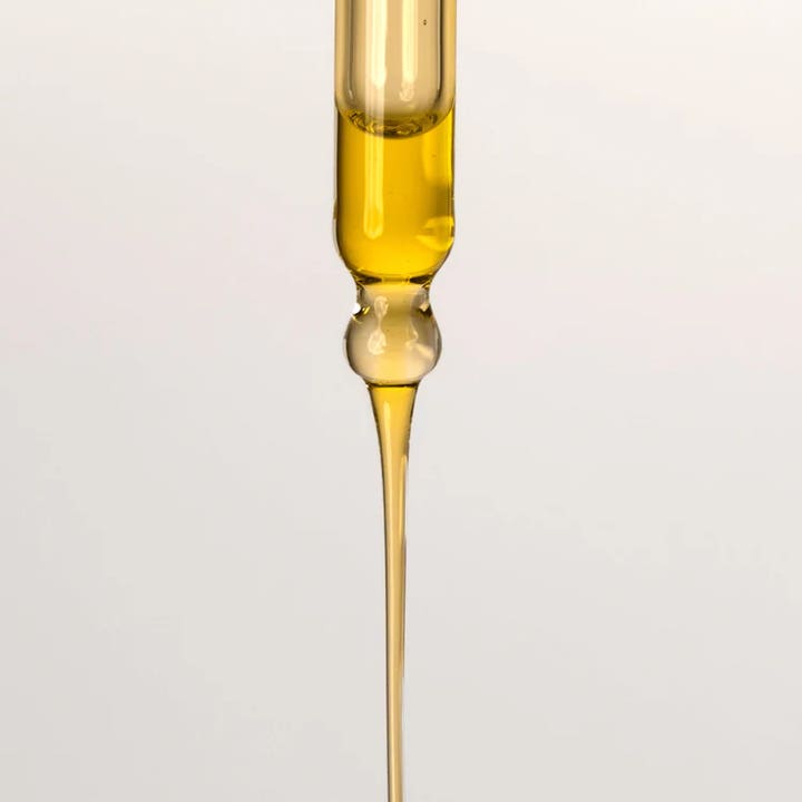 Codage Paris The Contouring Oil 100 ml kroppsolje med en rik og gyllen konsistens som drypper fra en glasspipett.
