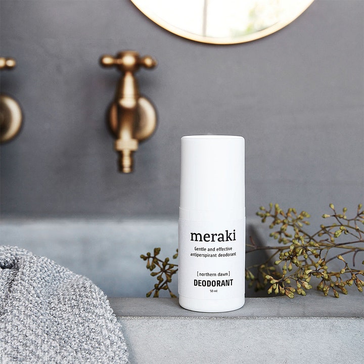 Meraki Northern Dawn Deodorant 50 ml effektiv antiperspirant i hvit hylse på en grå vask med tørkede planter