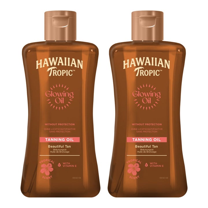 Hawaiian Tropic Glowing Oil sololje med vitamin E som gir glød i to brune plastflasker med gyllen olje
