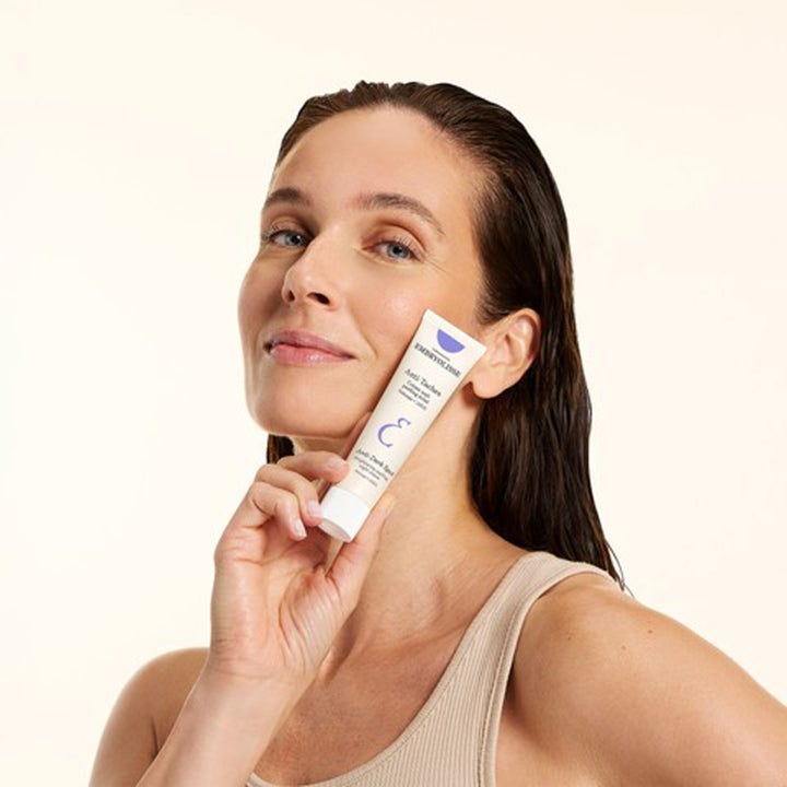 Embryolisse Brightening Dark Spot Night Peeling 40 ml nattkrem mot mørke flekker vist av kvinne som holder tuben
