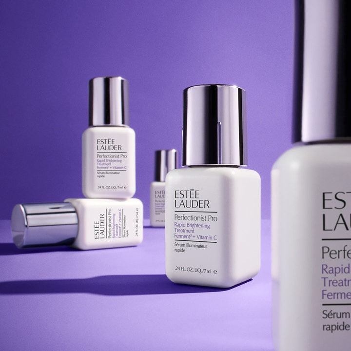 Estée Lauder Perfectionist Pro Rapid Brightening Treatment 50 ml serum med Vitamin C i hvite flasker på lilla bunn.