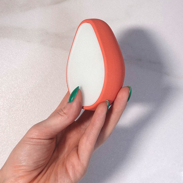 ANSWR Exfoliating Hair Removal Drop 1 stk eksfolierende hårfjerning oransje dråpeformet verktøy holdt i en hånd