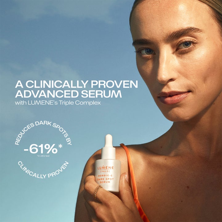 Lumene Dark Spot Serum 30 ml mot pigmentflekker holdes av en kvinne mot blå himmel med tekst om klinisk effekt.