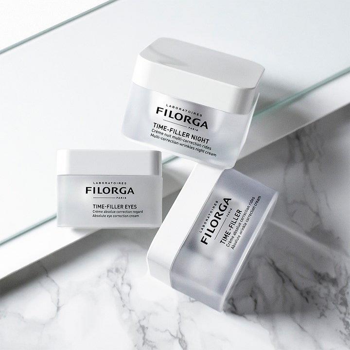 Filorga Time-Filler Night 5 XP 50 ml rynkereduserende nattkrem i frostet krukke sammen med andre produkter på marmor.