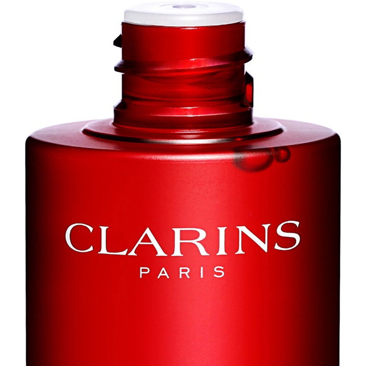 Clarins Super Restorative Treatment Essence 200 ml ansiktsvann i rød flaske med hvit logo uten kork