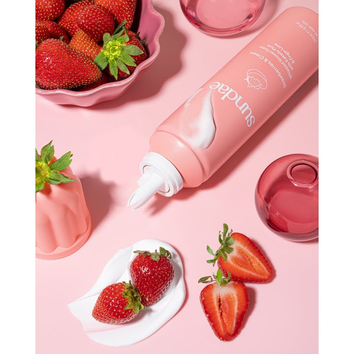 Sundae Whipped Shower Foam Strawberries & Cream 265 ml pleiende dusjsåpe i rosa flaske med hvitt skum og friske jordbær