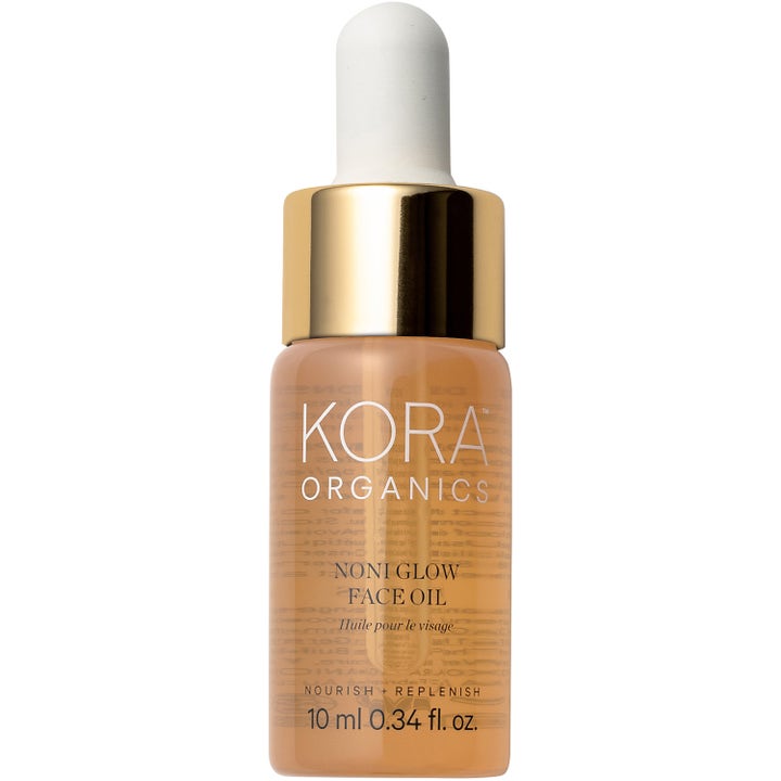 Kora Organics Noni Glow Face Oil 10 ml nærende ansiktsolje som gir glød i glassflaske med gulllokk og hvit pipette.
