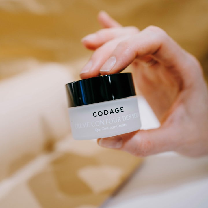 Codage Paris The Eye Contour Cream 15 ml anti-aging øyekrem i frostet glasskrukke holdt av en hånd