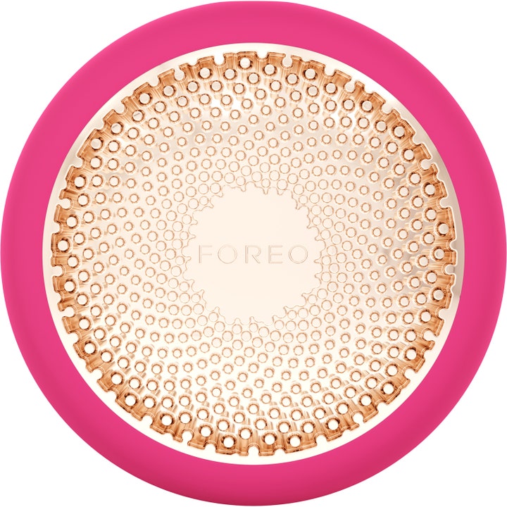 Foreo UFO 3 ansiktsbehandling som gir dyp glød i fuksia rosa silikon med mønstret plate i rosegull.