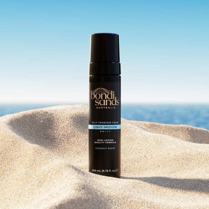 Bondi Sands Self Tanning Foam Light Medium 200 ml selvbruning i sort pumpeflaske stående i sanden ved havet