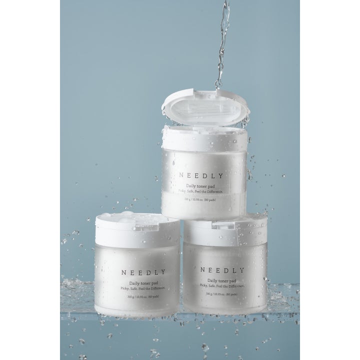 NEEDLY Daily Toner Pad 80 stk fuktighetsgivende toner pads i hvite krukker omgitt av friskt vannsprut.